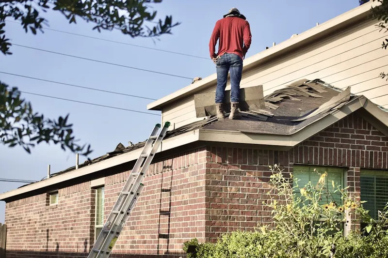 Professional roofer working on a residential roof in Kendall